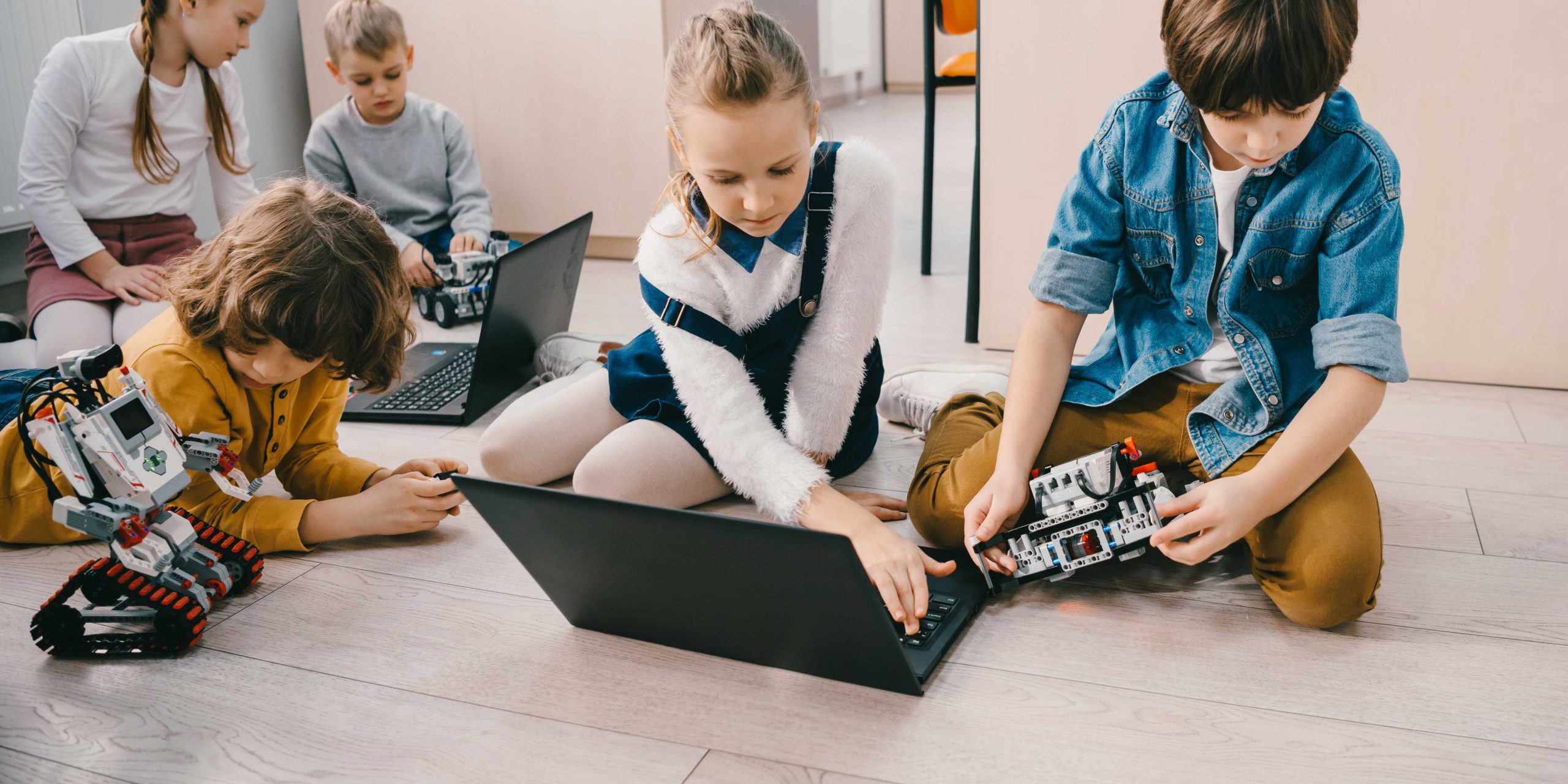 kids-programming-robots-with-laptops-while-sitting-GE4YGPA_11zon What-is-STEAM-education-and-why-it's-important-for-kids