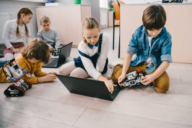 kids-programming-robots-with-laptops-while-sitting-GE4YGPA_11zon What-is-STEAM-education-and-why-it's-important-for-kids